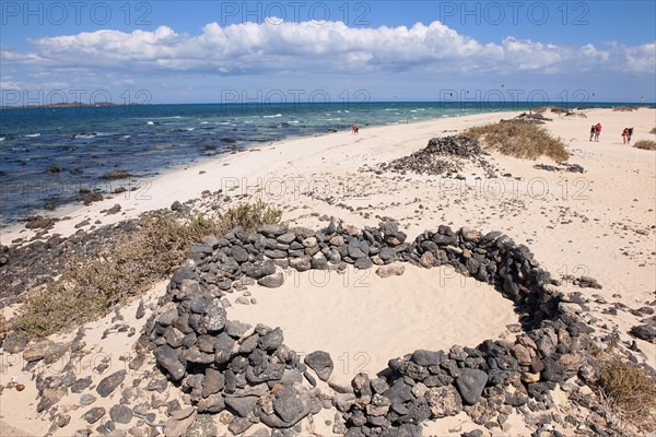 Stone castle built by tourists as a privacy screen windbreak on a sandy beach