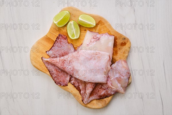 Top view of raw fresh unpeeled squid on wooden cutting board