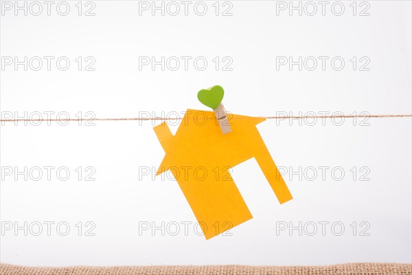Little paper house attached to a string with a heart clip