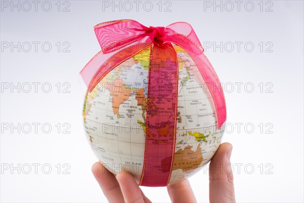 Globe tied with red ribbon on a white background