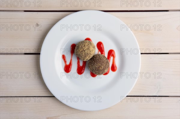 Chocolate truffles with biscuit powder. Rum balls and raspberry jam. Top view