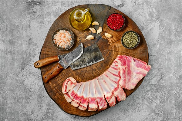 Raw fresh lamb flap ribs with ingredients on wooden log