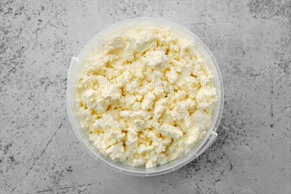 Top view of homemade cottage cheese in plastic bowl