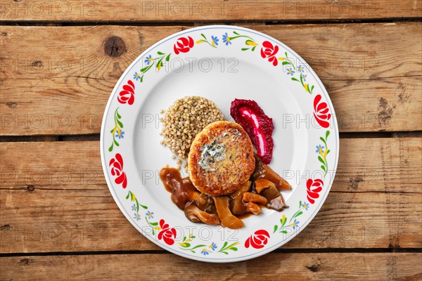 Top view of meat cutlet with honey mushroom and green buckwheat