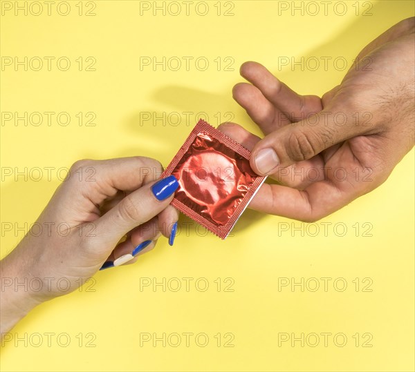 Close up man woman holding condom
