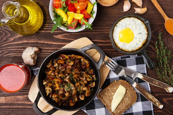 Fried mushrooms and egg in cas-iron skillet. Ingredients for rustic simple food