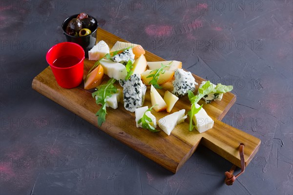 Cheese plate with honey and black and yellow olives