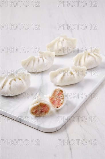 Frozen dumplings stuffed with liver and provencal herbs on marble serving plate