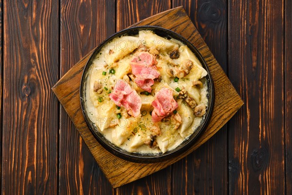 Top view of pan with fried meat dumplings with bacon and mushroom sauce