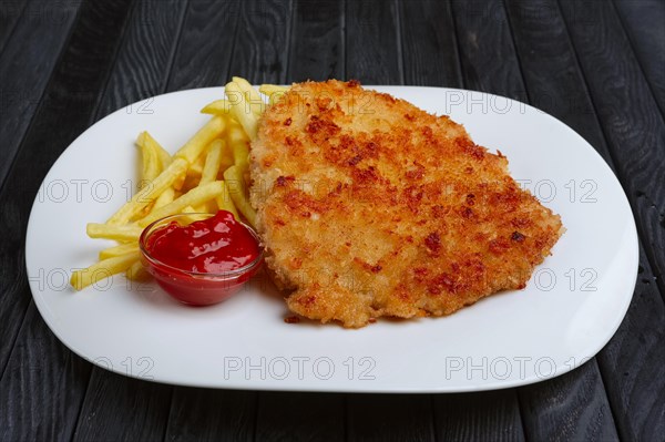 Fried chopped pork cutlet with potato balls and creamy sauce with mushroom and onion