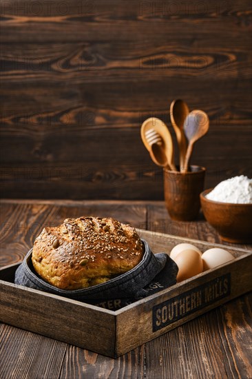 Fresh oats bread with sunflower seeds and sesame on wooden table