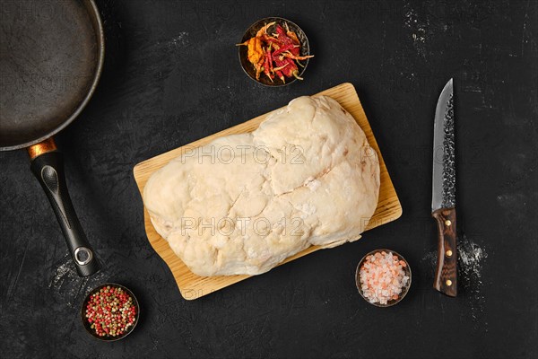 Overhead view of lamb fat tail on kitchen table with salt and pepper