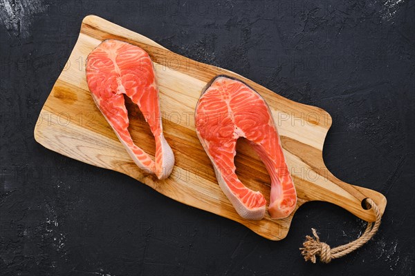 Raw fresh salmon steak on wooden cutting board