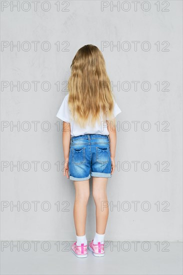 Back view of little child girl in white t-shirt