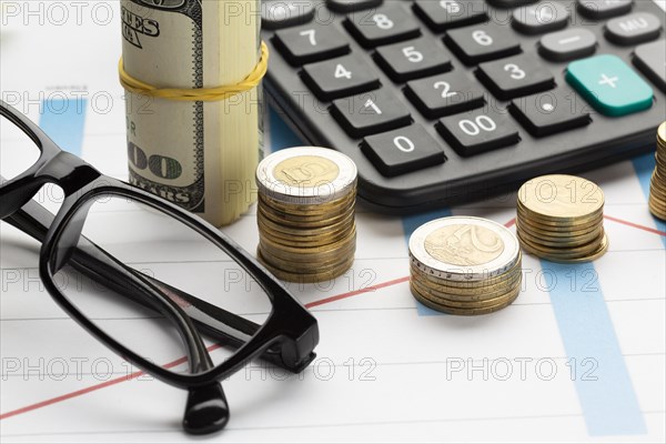 Close up coin pile near banknote stack