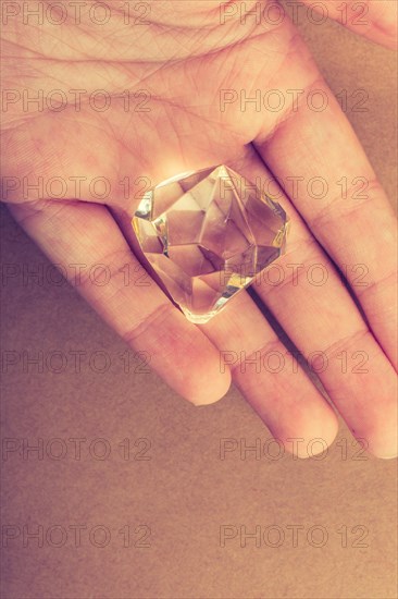 Fake diamond stone in hand in view