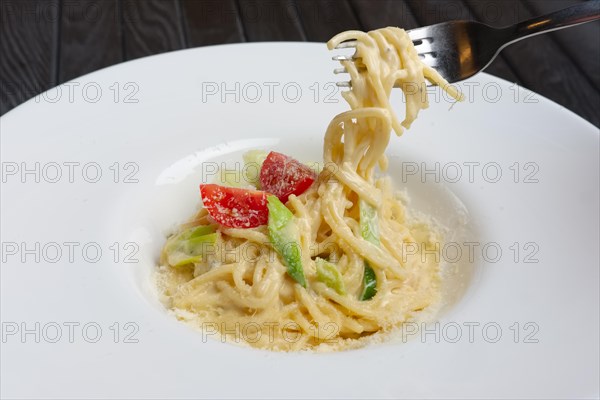 Plate with pasta served with bacon and ham