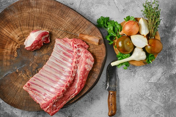 Top view of raw fresh lamb ribs on wooden slab