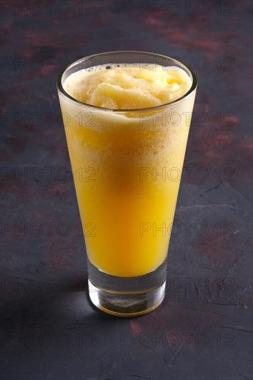 Glass of orange granizado. Crushed ice with fruit syrup beverage
