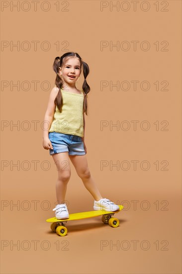 Young happy girl learning to ride on skateboard