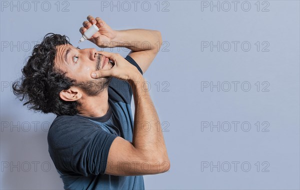 People applying refreshing drops to irritated eye. Man putting a dropper in his eye isolated. Man with irritated eye applying drops with a dropper