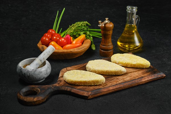 Semifinished homemade zander cutlet on a wooden serving board