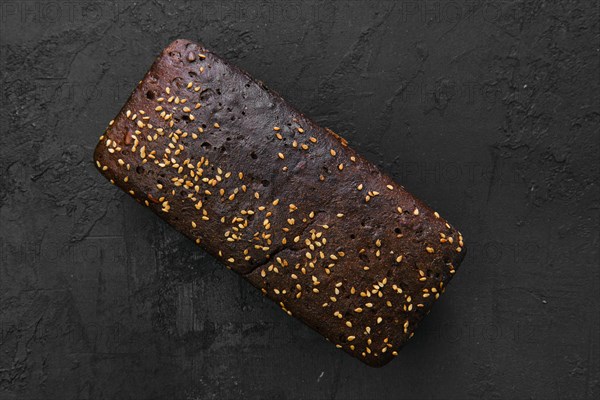 Top view of loaf of brown sourdough bread with sunflower seeds and sesame