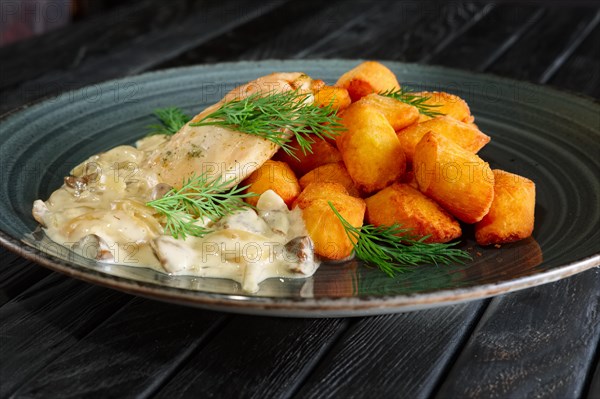 Potato balls with chicken fillet and mushroom and onion sauce