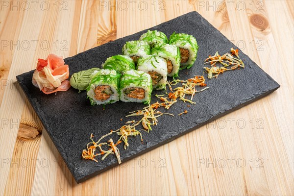 Set of rolls with wasabi and pickled ginger on stone serving board