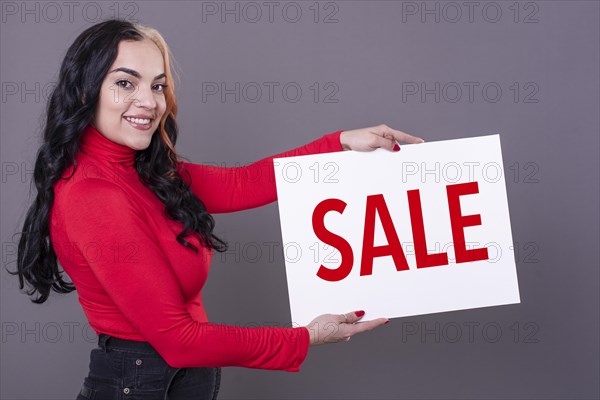 Beautiful woman holding a Sale sign. Commercial concept. Commerce