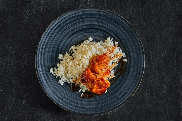 Top view of baked chicken fillet with rice and barbecue sauce