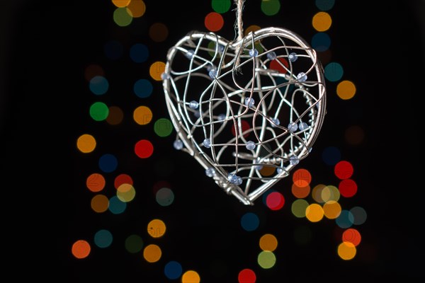 Heart shaped metal cage on a bokeh light background
