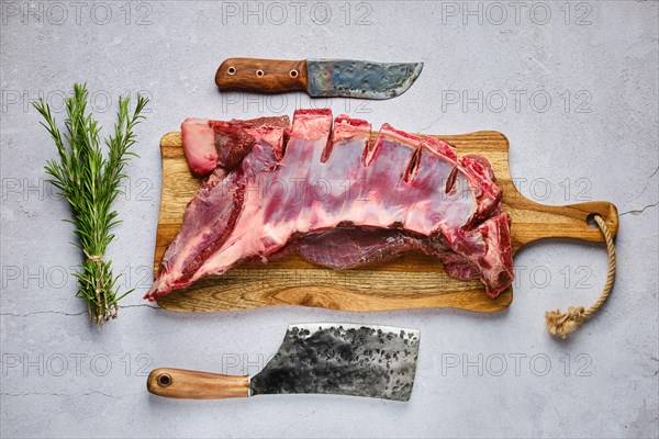 Overhead view of raw fresh deer ribs with spice and herb over concrete background