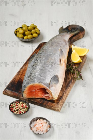 Headless fresh yellow tailed lacedra on wooden cutting board