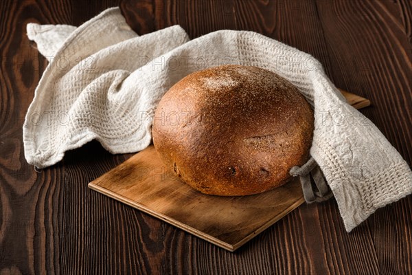 Rue brown bread on cutting board on the table