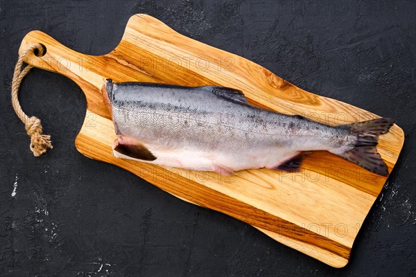 Top view of raw fresh headless pink salmon on wooden cutting board