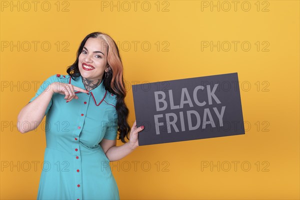 Beautiful woman holding and pointing a Black Friday sign. Commercial concept. Commerce