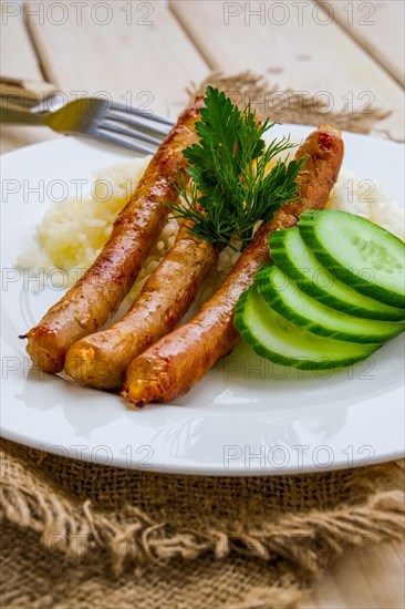 Fried sausage with mashed potato and fresh cucumber