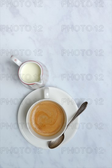 Cup with coffee and pot of milk