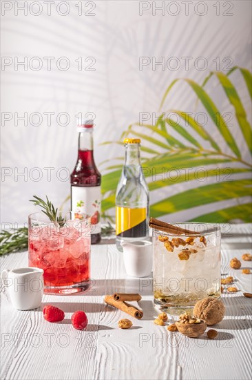 Espresso-tonic refreshing drink with different fruits and syrups on wooden table under morning sun