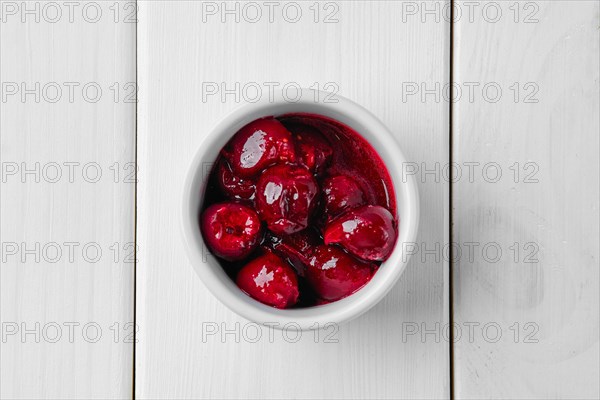 Top view of cherry sauce in ceramic gravy boat