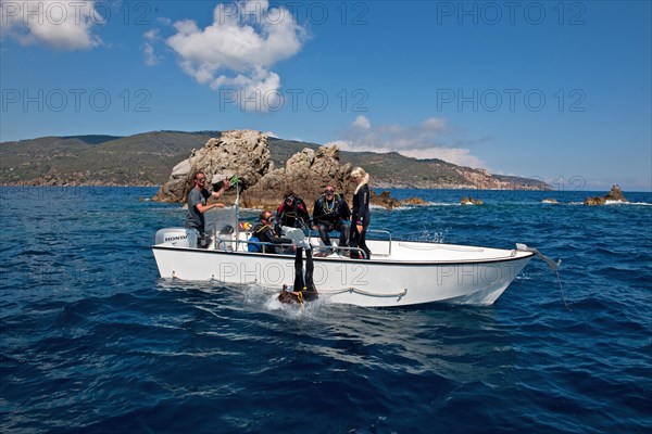 Divers drop backwards over side of dive boat small dive boat into water