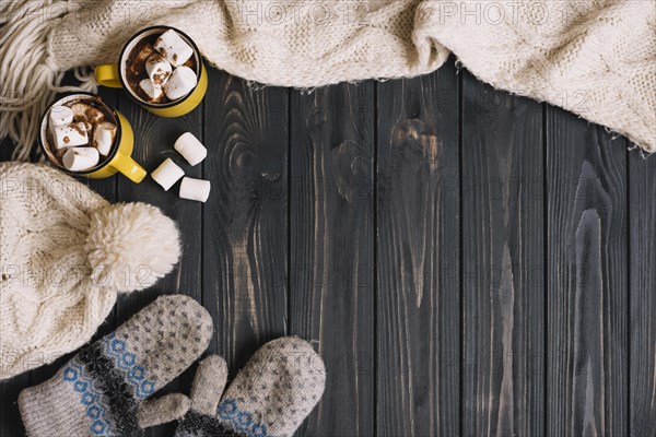 Mugs with marshmallows near warm wear