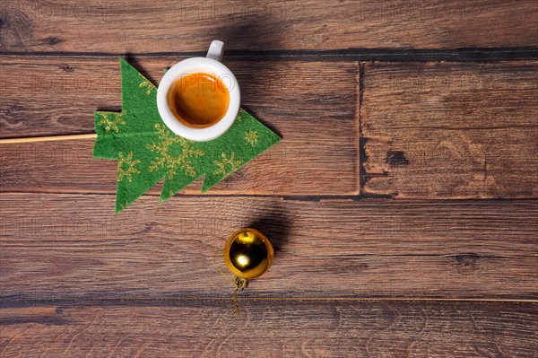 Top view of coffee cup and christmas tree toys on wooden table