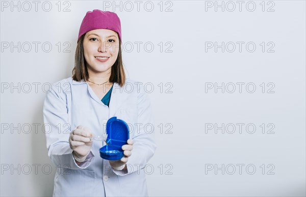 A dentist with retainers on isolated background