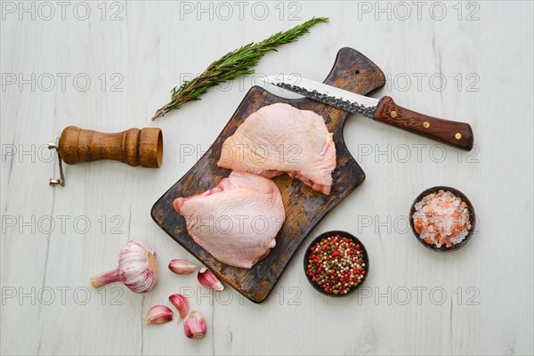 Raw chicken thighs on wooden cutting board ready for cooking