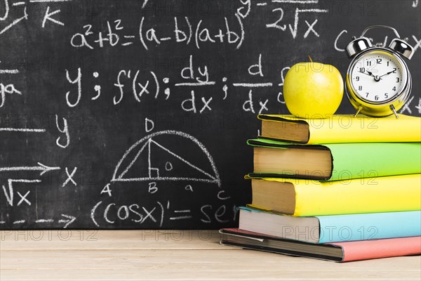 School desk with textbooks near blackboard