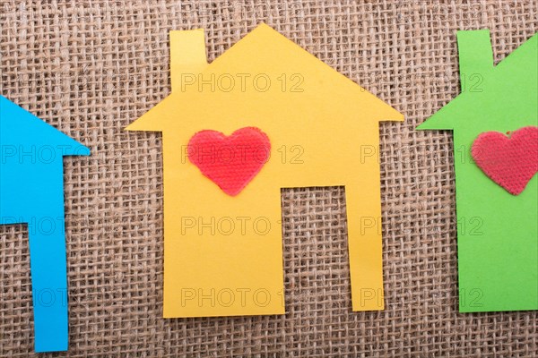 Heart shape on house shape cut out of paper with a canvas background