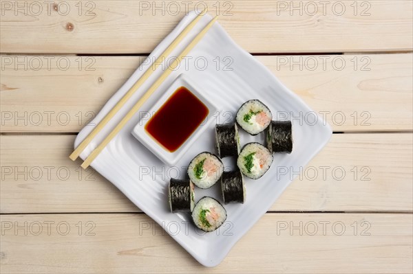 Top view of plate with shrimp rolls with hashi and siy sauce