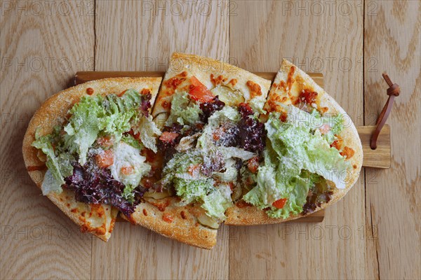 Top view of freshly baked focaccia with salad leaves